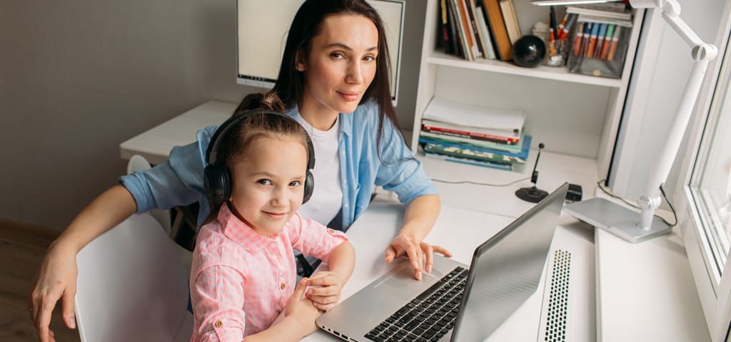 Une mère aide sa fille avec son apprentissage grâce à un ordinateur